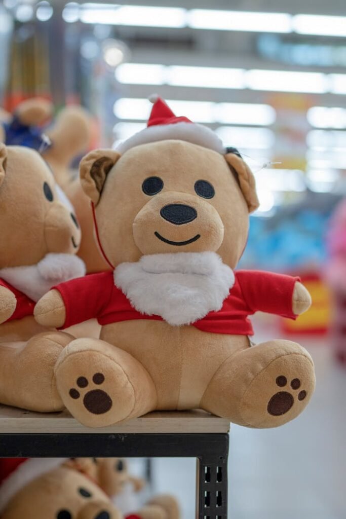 Adorable teddy bear dressed in Santa outfit on store shelf, perfect for Christmas gifting.