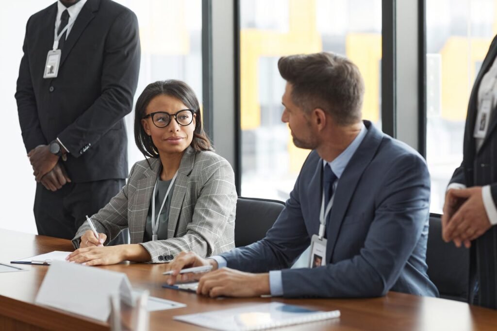 Diverse business professionals discussing strategy during a modern board meeting.
